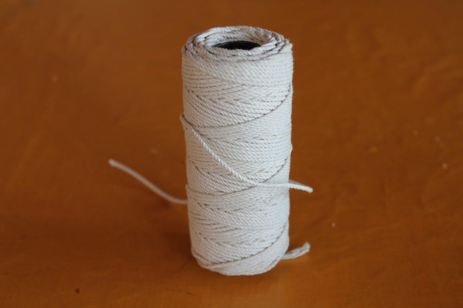 Close-up of the white thread spool, on the brown surface