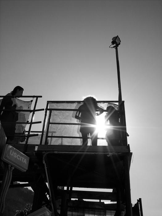 Black and white photo of the people on construction, at background with backlight