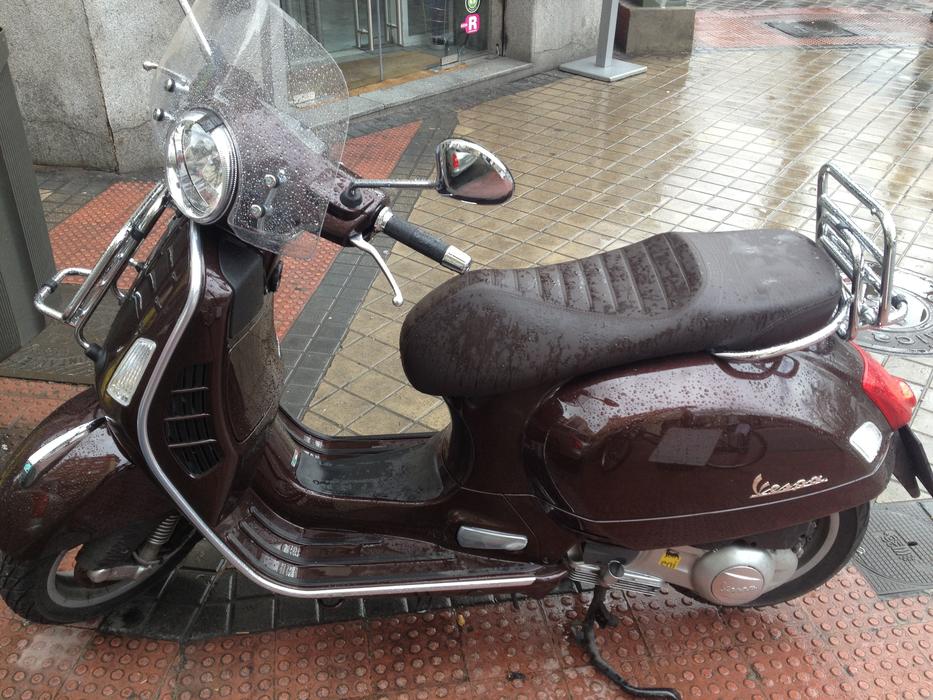 Shiny scooter on the colorful pavement in water