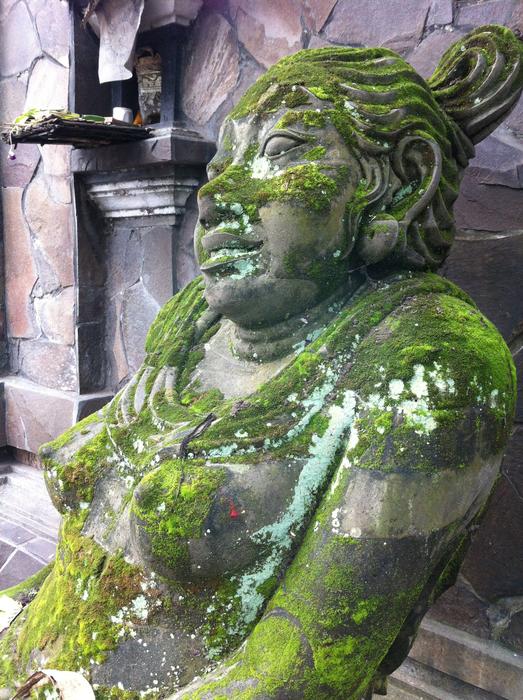 stone statue of a woman in green moss