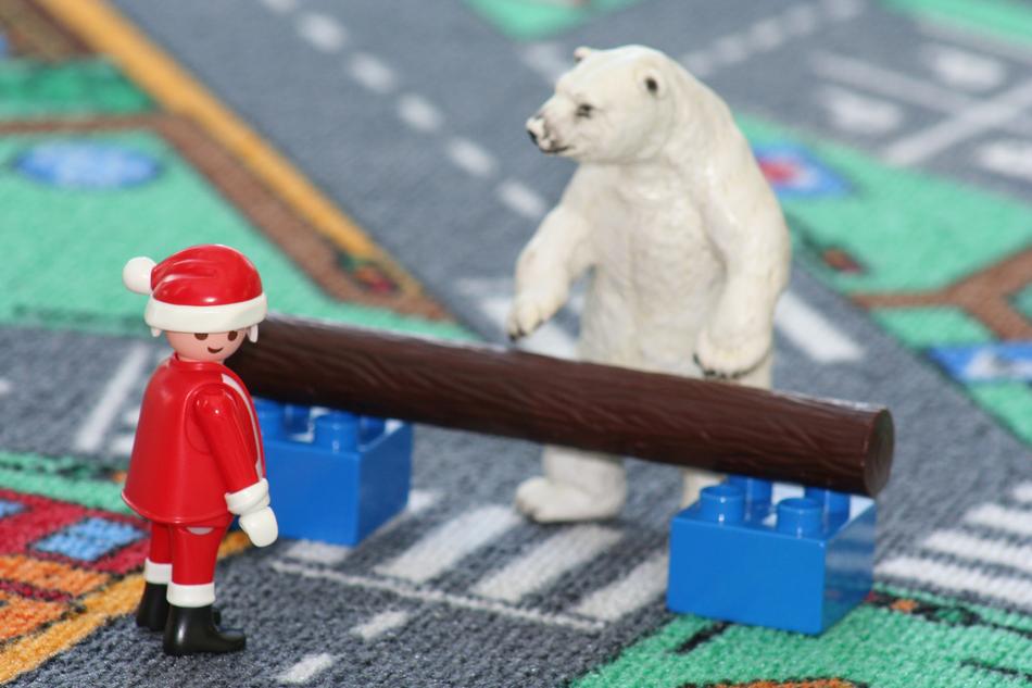 Figures Santa Claus and polar bear, behind the pole, on the colorful carpet with aerial view