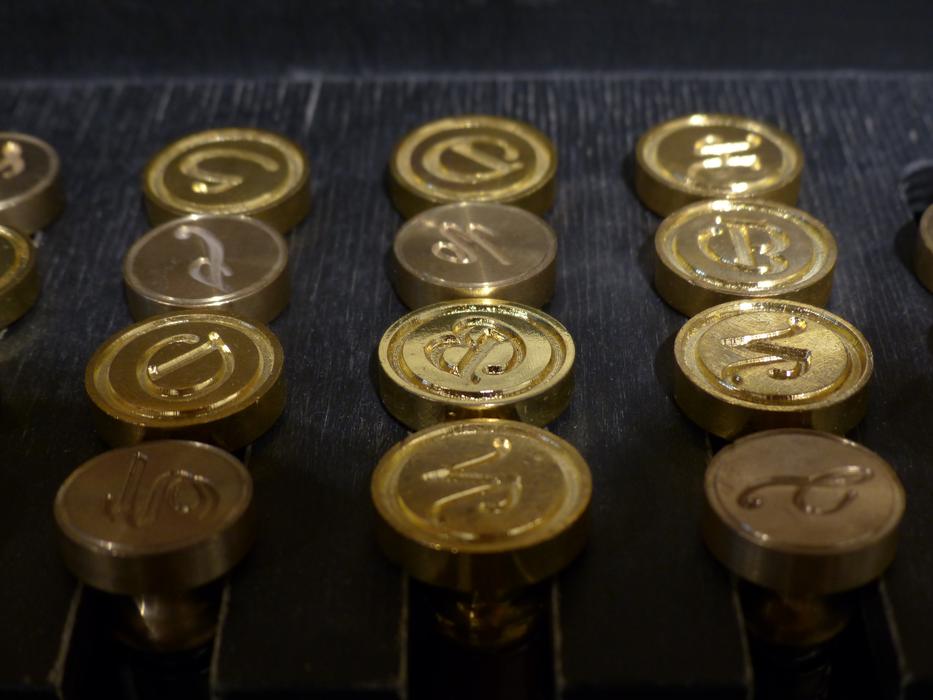 Shiny, round, golden stamps in light and shadow