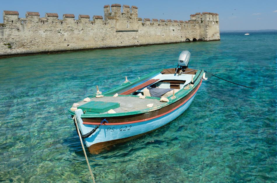 boat near the old fortress in sirmione