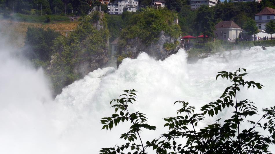 Beautiful Rhine waterfall among the green plants and buildings, in Schaffhausen, Switzerland