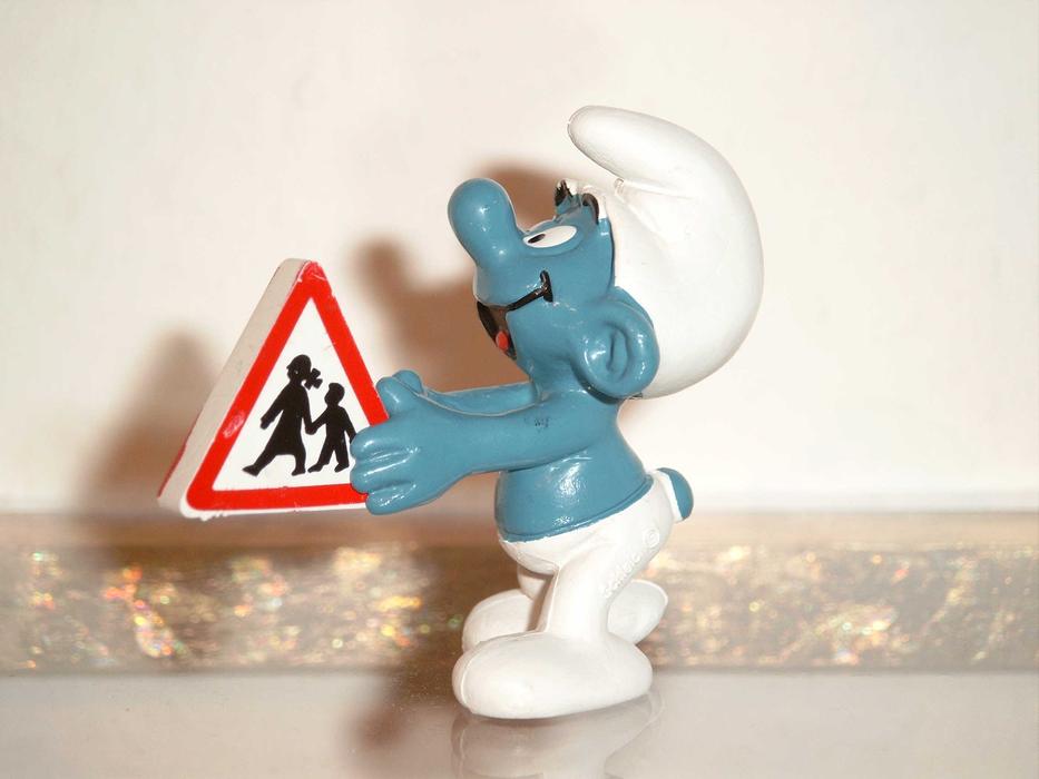 Blue Smurf holding traffic sign, plastic figurine