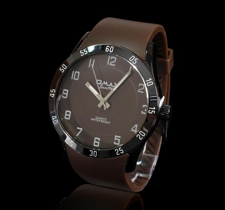 Close-up of the shiny, brown 'Omax' male watch, at black background