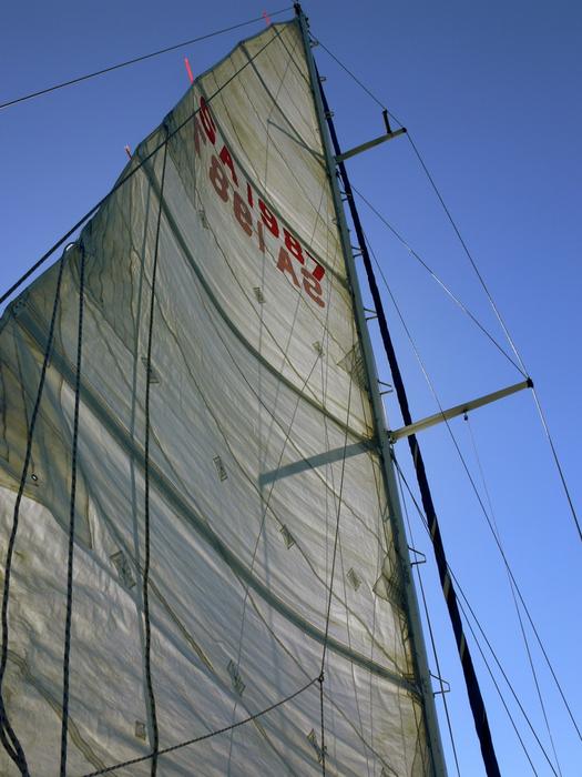 Close -of the sail of the yacht, under the blue sky