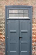 Grey door with window, in the colorful brick building