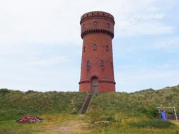 Beautiful landscape with water tower on the hills with green and yellow grass, in Borkum, Germany