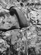 Black and white photo with close-up of the water source, in the rocks