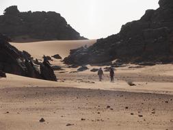 People hiking in the desert, among the mountains