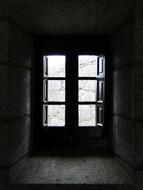 Black and white photo with interior of the building with light in the windows