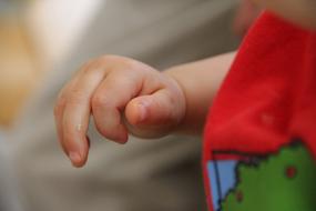 Close-up of the cute baby hand, near the colorful cloth