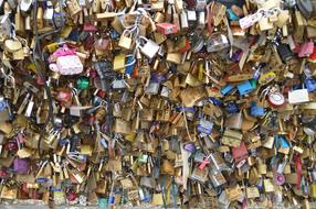 Close-up of the colorful, shiny padlocks on the Bridge of Arts in sunlight, in Paris, France