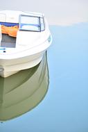 white boat anchored on calm water close up