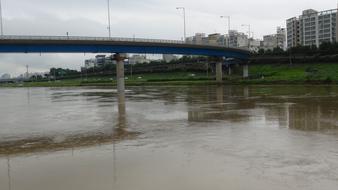 Landscape of Junja, Kenya, Africa, with the buildings and bridge above the river, after the rain