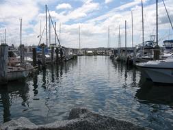 Boats on the water with ripple, in the dock, under the blue sky with clouds