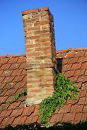 Colorful brick chimney on the house roof, under the blue sky