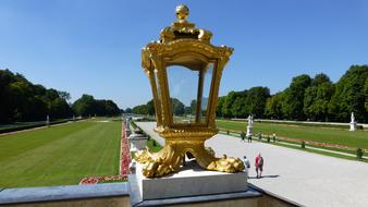 Beautiful, shiny, gold lantern among the colorful plants, near the people, in Castle Nymphenburg, Munich, Bavaria, Germany