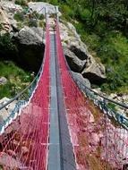 red rope bridge over the river