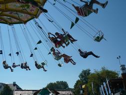 People on the chain carousel, near the buildings, at the Year market