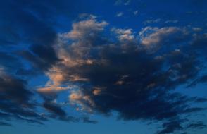 dark clouds against blue sky