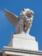 Beautiful statue of the lion with wings, in sunlight, under the blue sky