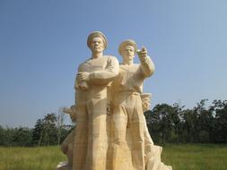 Sculpture of the people, among the plants, at the museum, under the blue sky