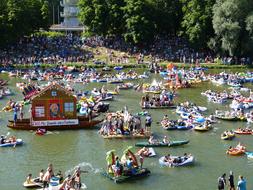 People swimming in Danube River, near the shore with green plants, in Ulm, Germany