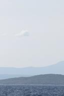 silhouettes of mountains above the water on the horizon