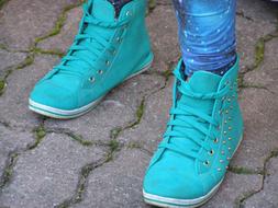 Close-up of the turquoise boots on the feet, on the pavement