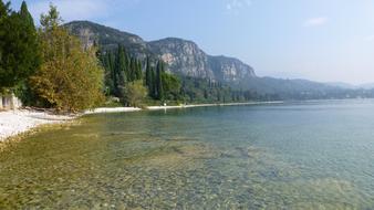 Beautiful landscape of the Garda Lake coast with colorful plants and mountains