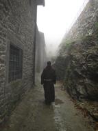 Monk near the monastery, on the beautiful landscape in fog