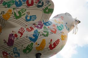 Colorful Ulm Spatz sparrow statue with handprints, in Germany, under the blue sky with clouds