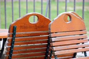 Colorful, wooden chairs with signs, near the fence and green grass