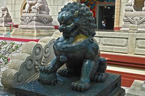 Close-up of the lion sculpture near the other sculptures and building