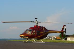 Colorful, shiny helicopter at the airport, near the buildings