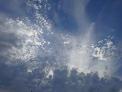 Beautiful, blue sky with grey and white clouds in sunlight