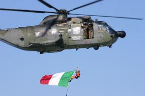 Flying helicopter of Italians, with the flag, at blue sky on background