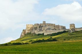 Beautiful landscape with the Spis Castle on the colorful hill, in Slovakia, under the blue sky with cloudss