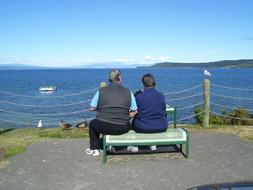 people on a bench on the shore of Lake Taupo