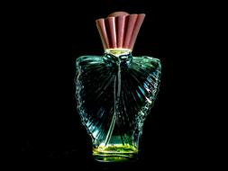 Close-up of the beautiful and colorful, shiny cologne bottle, at black background