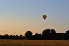 hot air balloon flies over countryside
