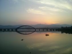 Landscape with the bridge above the Soyang River in Chuncheon, South Korea, at background with mountains and colorful and beautiful sunset