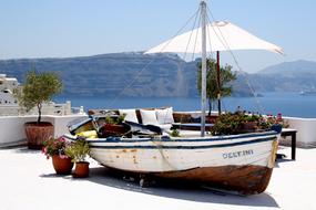 Colorful boat on the beautiful coast with colorful plants, in sunlight, near the mountains