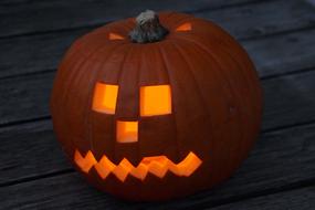 pumpkin face on a wooden surface in the dark