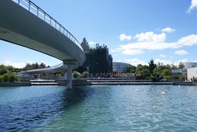 Landscape with the bridge, with the colorful plants and buildings on the shore, in France, under the blue sky with white clouds