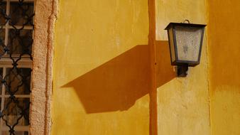 Lamp with the shadow, near the window, on the wall of the Kiscelli Museum in Budapest, Hungary