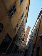 Beautiful buildings and tower in Noli, Italy, under the blue sky