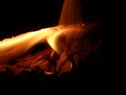 Close-up of the colorful and beautiful fire with wood, among the darkness, at the night